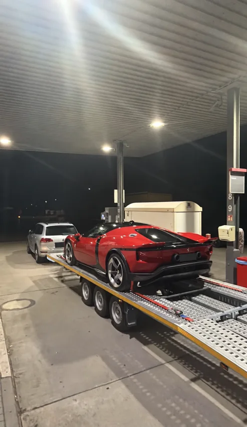 Ferrari rouge sur une remorque ouverte, de nuit