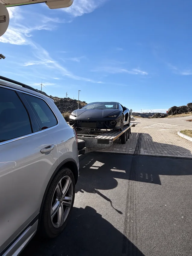 Voiture noire transportée sur une remorque ouverte
