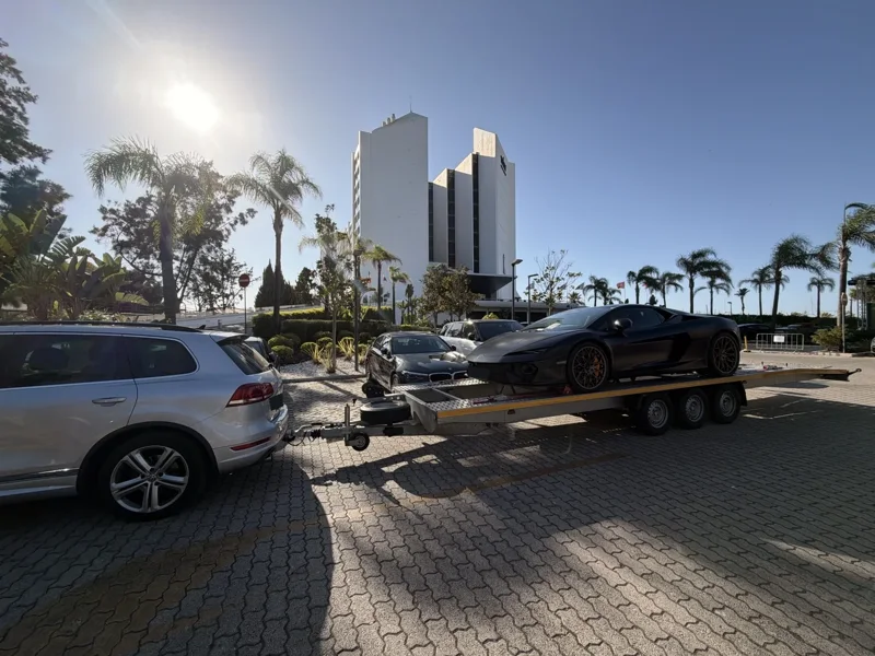 Lamborghini noire sur une remorque attelée à un SUV blanc