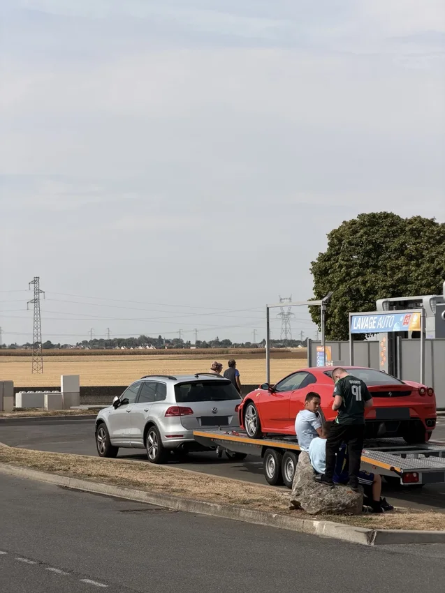 Ferrari rouge sur une remorque ouverte lors d’une halte